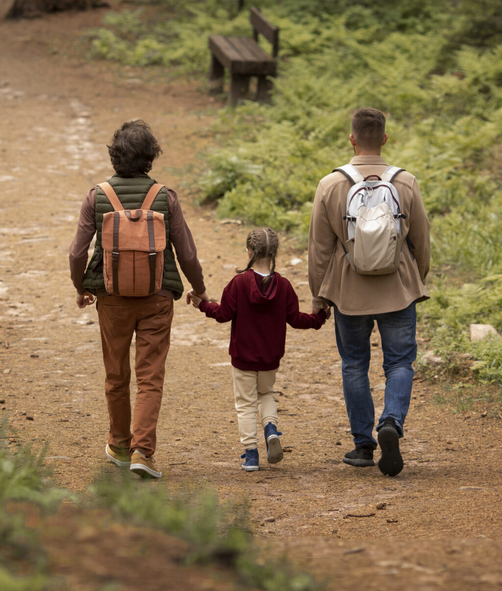 Parents walking on a nature trail with a child.